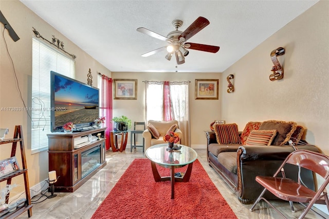 living room with ceiling fan and a textured ceiling