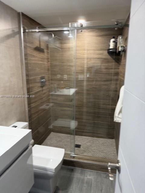 bathroom featuring vanity, toilet, and an enclosed shower