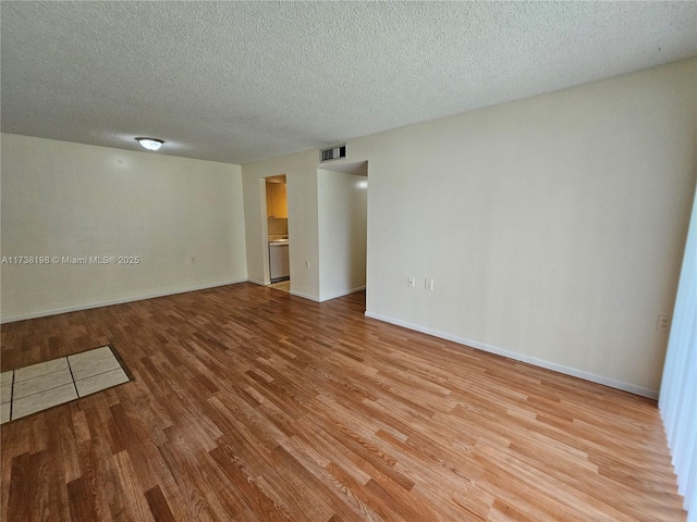 spare room with light hardwood / wood-style flooring and a textured ceiling