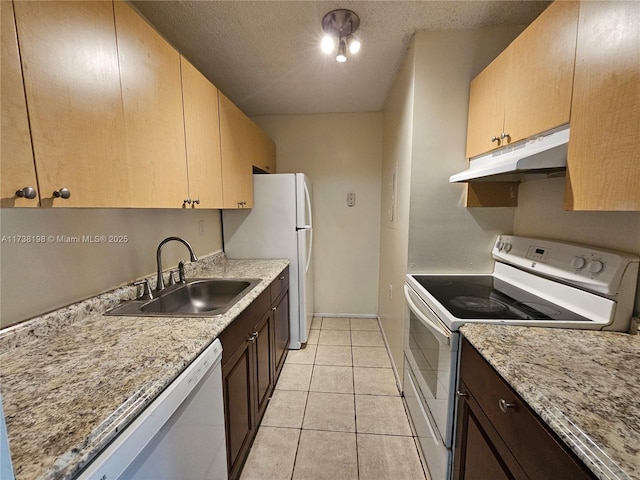 kitchen featuring white appliances, light stone countertops, sink, and light tile patterned floors