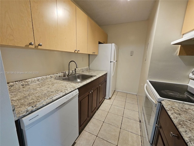 kitchen with light tile patterned flooring, dark brown cabinetry, sink, white appliances, and light stone countertops