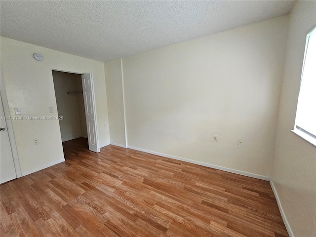 spare room featuring a textured ceiling and light wood-type flooring