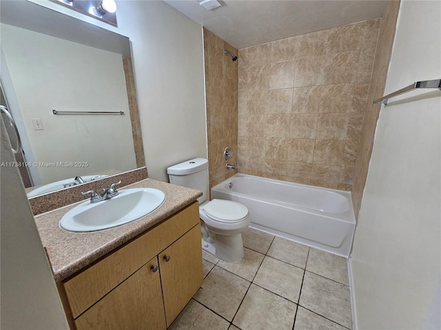 full bathroom featuring tile patterned flooring, vanity, tiled shower / bath combo, and toilet