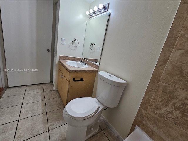 bathroom with tile patterned flooring, vanity, and toilet