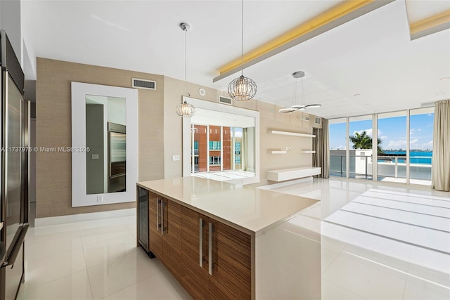 kitchen featuring beverage cooler, a wall of windows, hanging light fixtures, light tile patterned floors, and ceiling fan