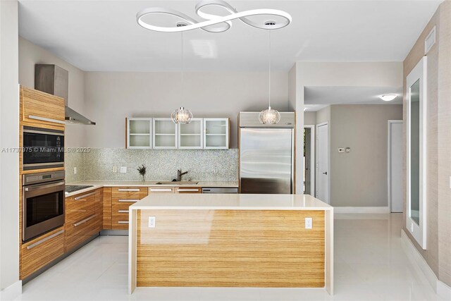 kitchen featuring sink, decorative light fixtures, black appliances, decorative backsplash, and wall chimney range hood