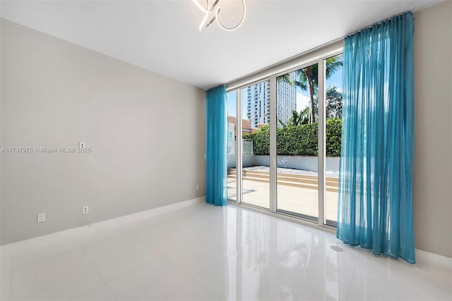 spare room featuring tile patterned floors and a wall of windows