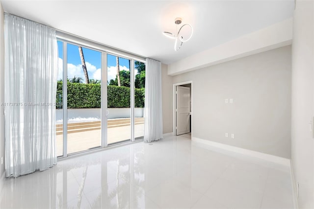 empty room featuring floor to ceiling windows and light tile patterned flooring