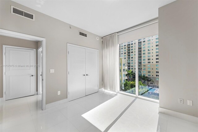 bedroom with light tile patterned floors and a closet