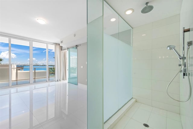 bathroom with expansive windows, a shower, a water view, and tile patterned floors