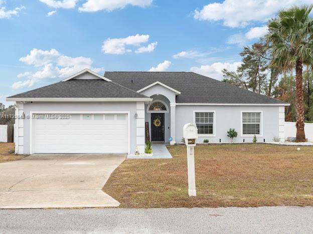 ranch-style home with a garage and a front lawn