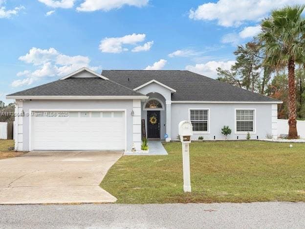 single story home with a garage, a front yard, concrete driveway, and stucco siding