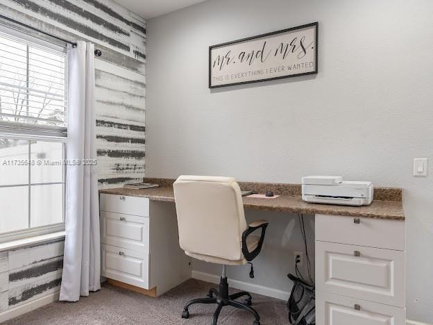 office area featuring light carpet and built in desk