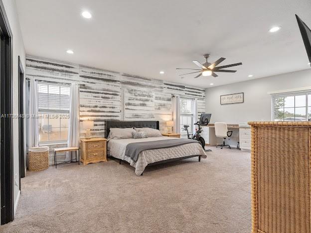 bedroom with ceiling fan, a spacious closet, and carpet