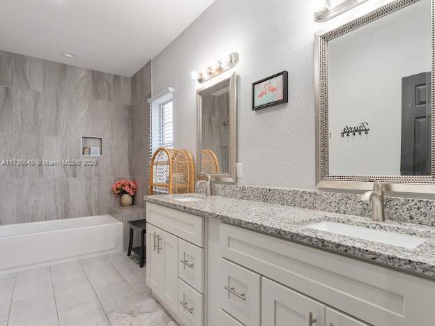 bathroom with vanity and tiled shower / bath