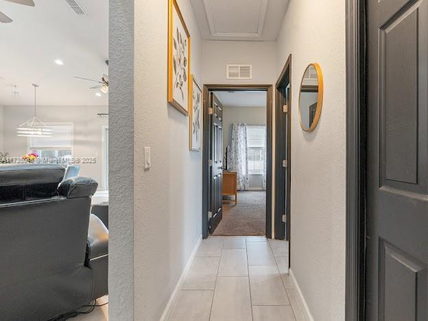 hall with light tile patterned floors and plenty of natural light