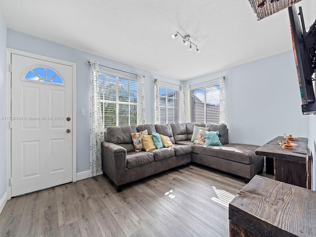 living room with light hardwood / wood-style floors and a textured ceiling