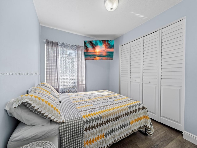 bedroom with dark hardwood / wood-style flooring and a closet