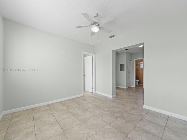 unfurnished room with light tile patterned floors, electric panel, and ceiling fan