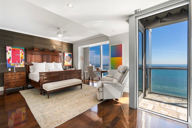 bedroom featuring ornamental molding, dark hardwood / wood-style floors, and a water view