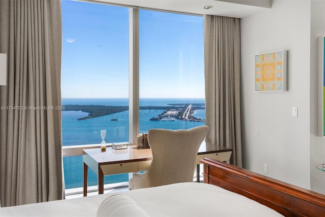 bedroom featuring a water view and floor to ceiling windows