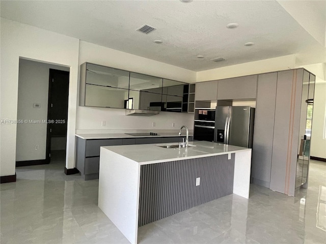 kitchen with visible vents, modern cabinets, black appliances, gray cabinets, and a sink