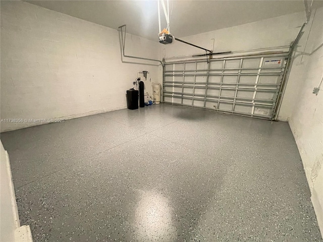 garage with concrete block wall and a garage door opener