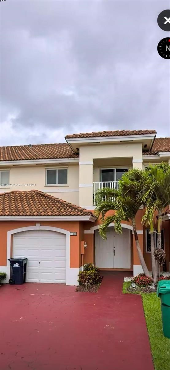 view of front of property featuring a garage and a balcony