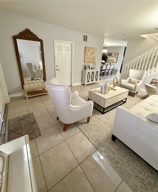 tiled living room with a notable chandelier