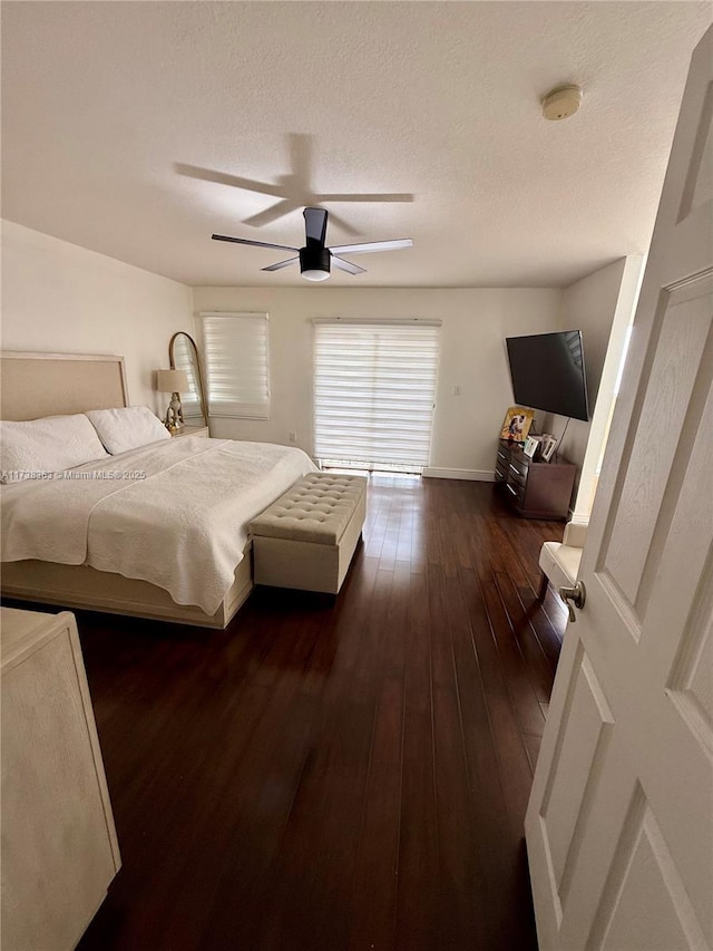 bedroom featuring ceiling fan, dark hardwood / wood-style flooring, and a textured ceiling