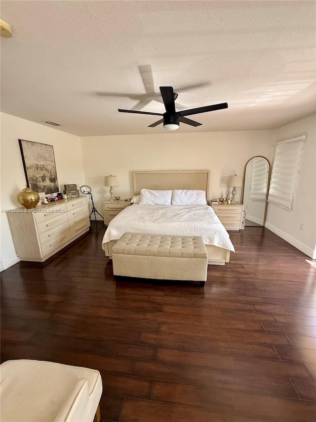 bedroom with ceiling fan, dark hardwood / wood-style floors, and a textured ceiling