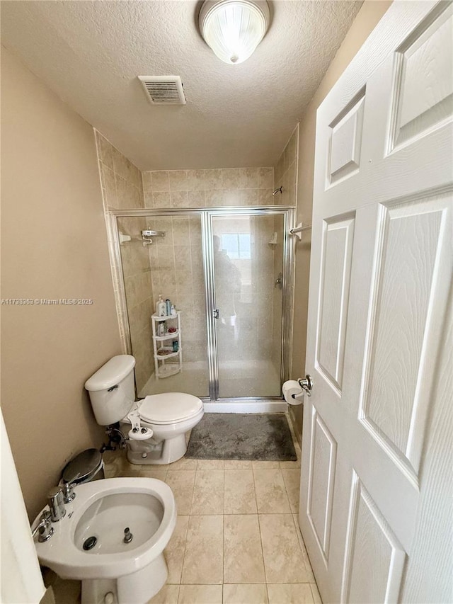 bathroom with a bidet, an enclosed shower, a textured ceiling, and toilet