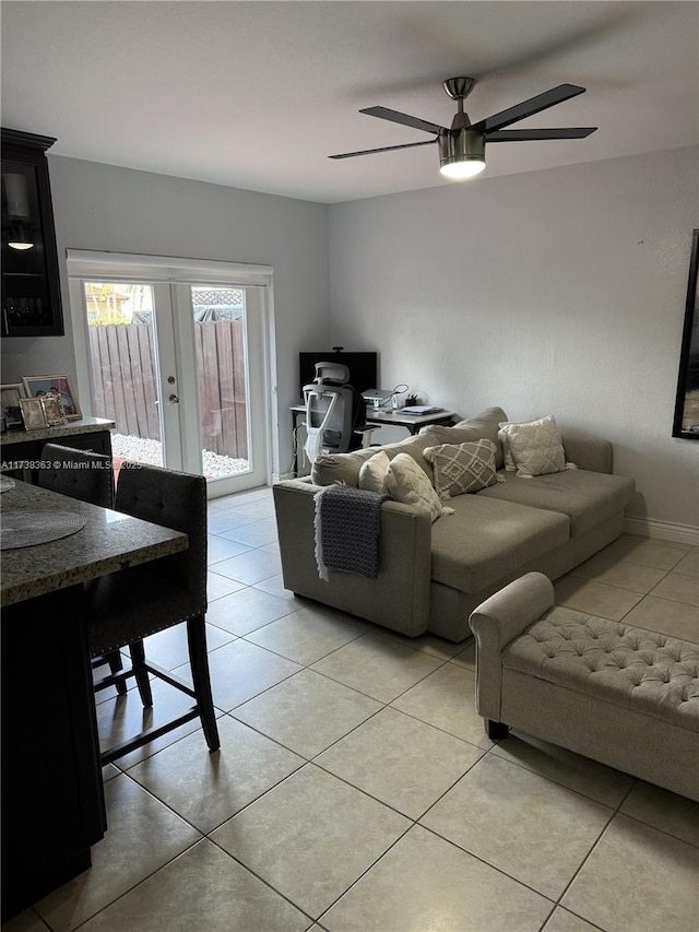 tiled living room featuring french doors and ceiling fan