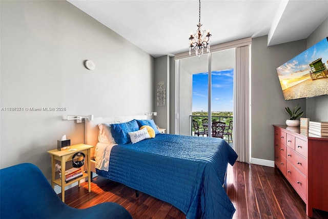 bedroom featuring dark hardwood / wood-style flooring, access to exterior, a wall of windows, and an inviting chandelier