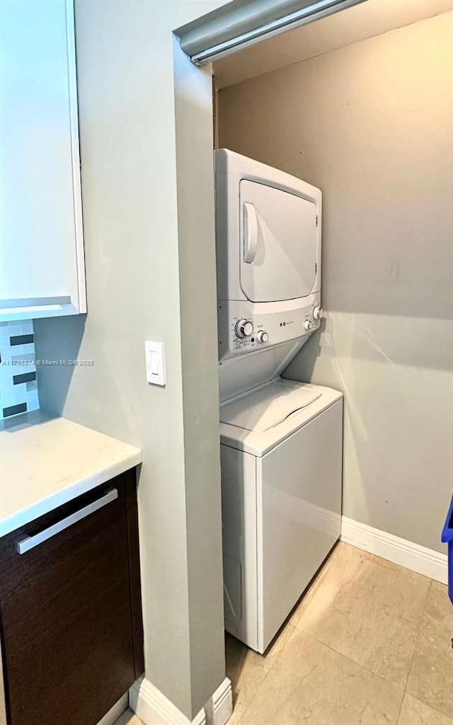 washroom featuring stacked washer / drying machine