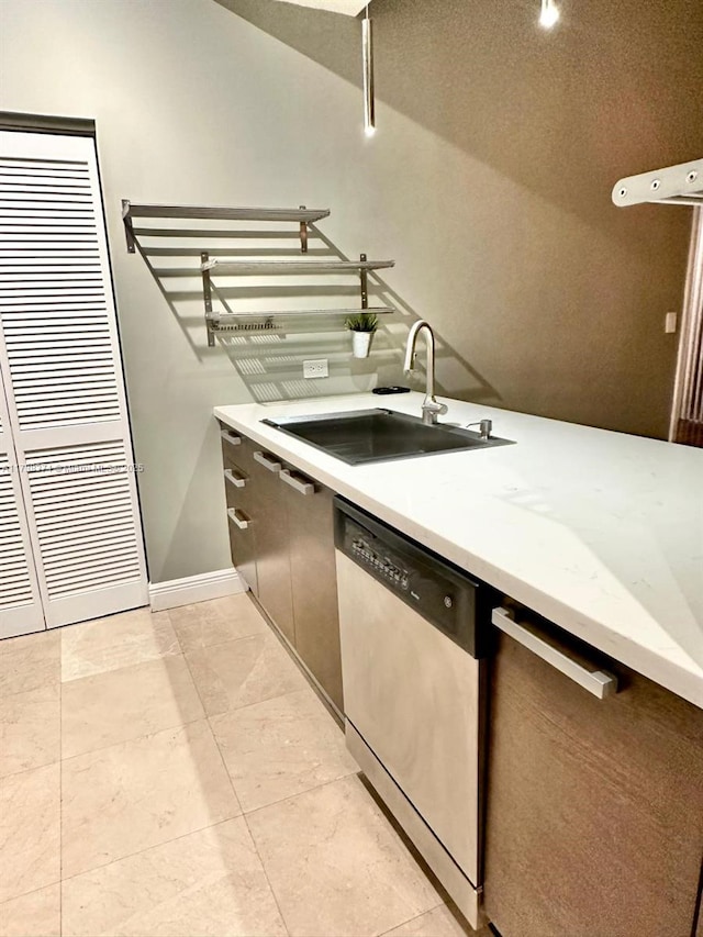 kitchen with sink, stainless steel dishwasher, and light tile patterned floors