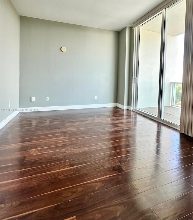 empty room with dark hardwood / wood-style flooring