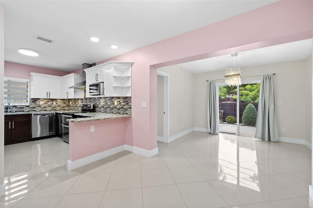 kitchen with white cabinets, decorative backsplash, light tile patterned floors, stainless steel appliances, and light stone countertops