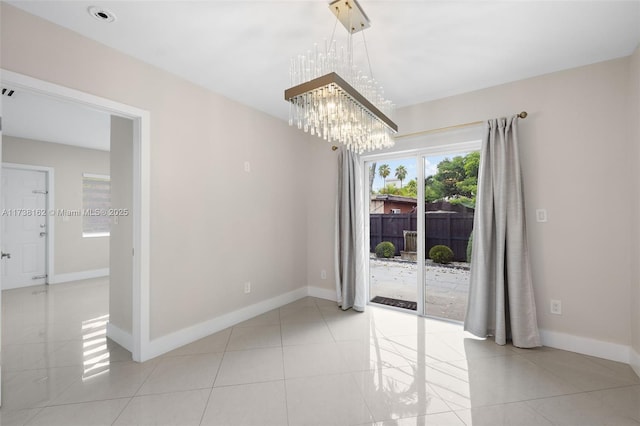 empty room featuring light tile patterned floors and a notable chandelier