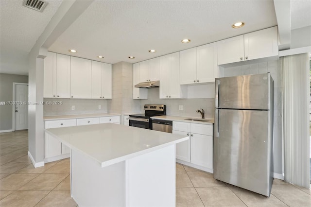 kitchen with stainless steel appliances, white cabinetry, and a kitchen island