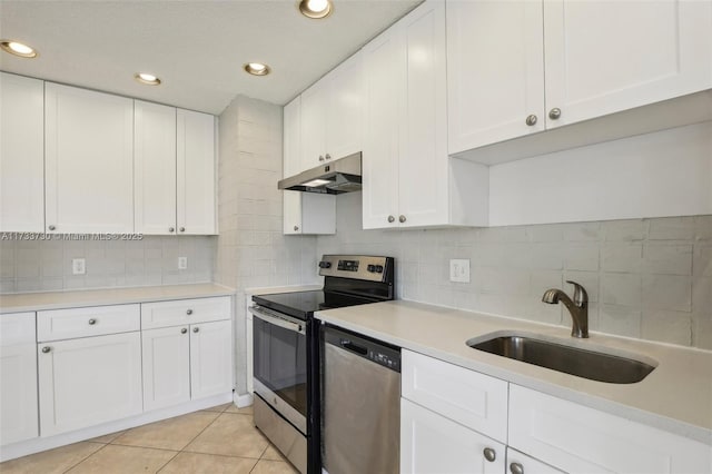 kitchen featuring sink, white cabinetry, light tile patterned floors, stainless steel appliances, and backsplash