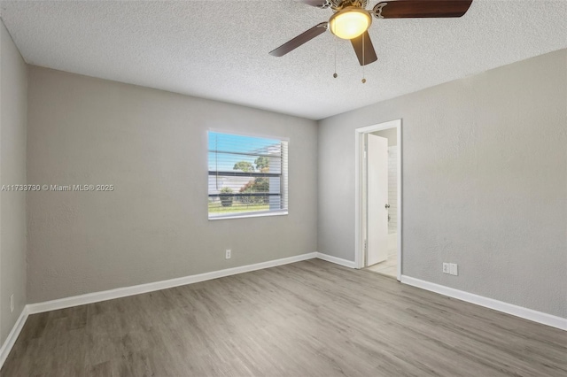 spare room with ceiling fan, hardwood / wood-style flooring, and a textured ceiling