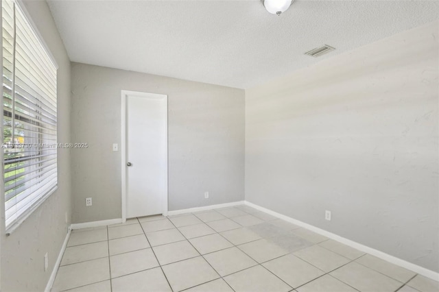 unfurnished room with a textured ceiling