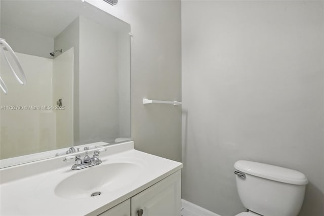 bathroom featuring walk in shower, vanity, and toilet