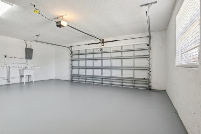 garage featuring sink, a garage door opener, and electric panel