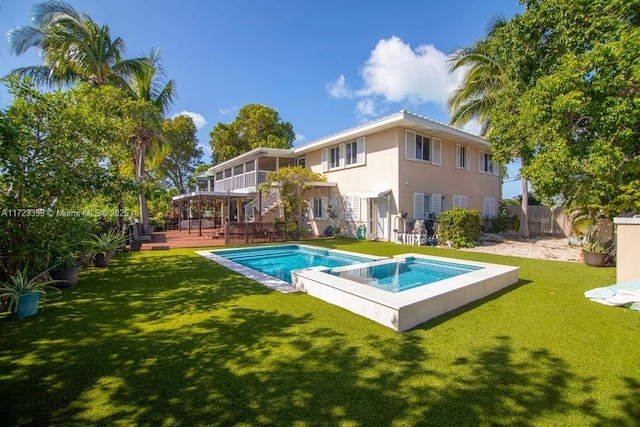 back of property featuring a pool with hot tub and a lawn