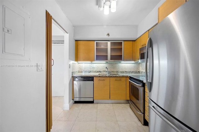 kitchen featuring light tile patterned flooring, tasteful backsplash, sink, stainless steel appliances, and light stone countertops