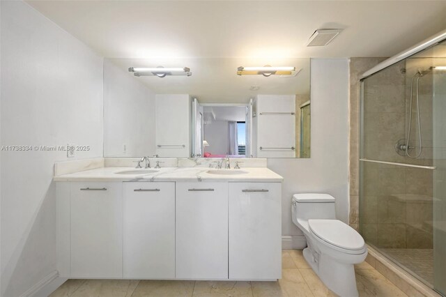 bathroom featuring vanity, toilet, and a shower with shower door