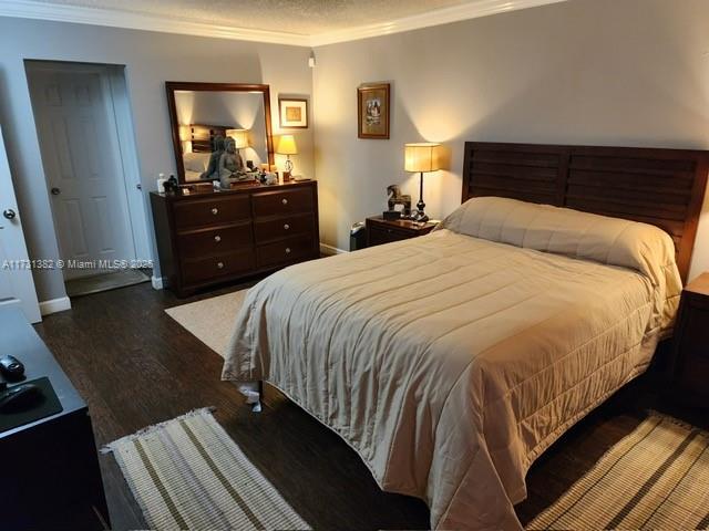 bedroom featuring dark hardwood / wood-style flooring and crown molding