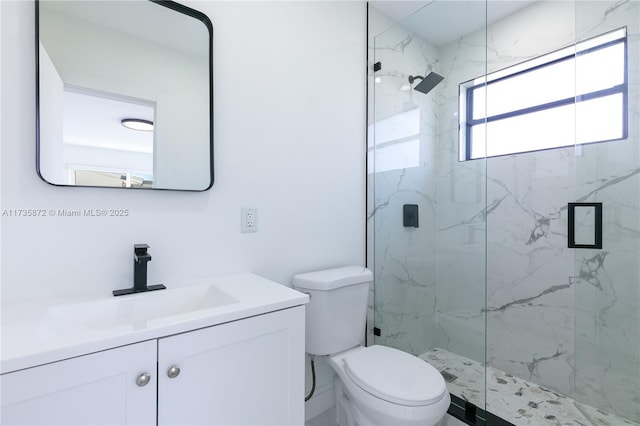 bathroom featuring vanity, a shower with door, and toilet